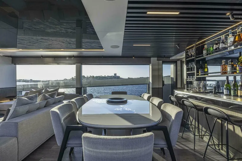 Slide: The Image of Luxurious interior of 2026 Pearl 82 yacht with dining area and bar, overlooking the sea. - 16