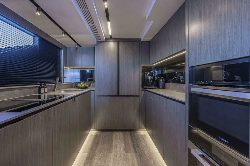 Slide: The Image of Modern kitchen with sleek cabinetry, ambient lighting, and high-end appliances in a Pearl 82 yacht, 2026 model. - 19