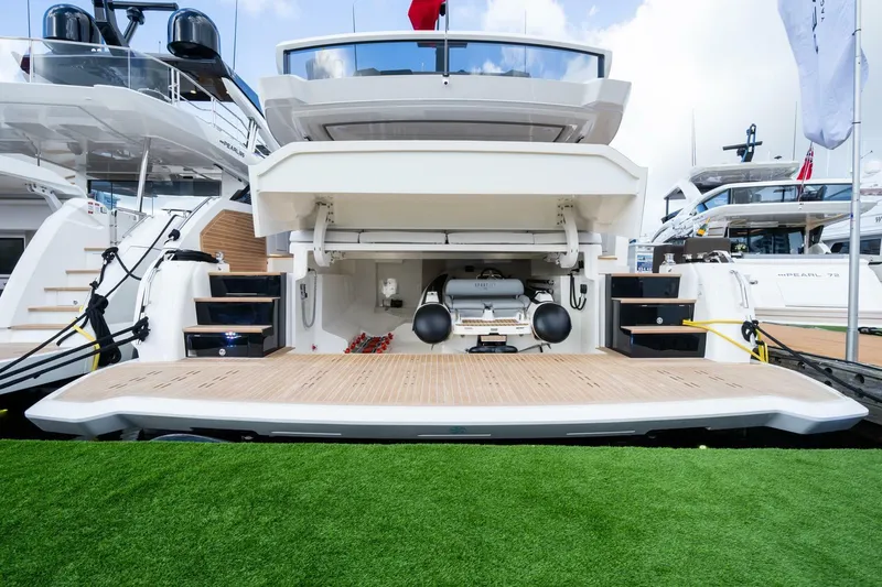 Slide: The Image of Luxury yacht Pearl 82, 2026 model, with open deck and storage area, docked at marina. - 42