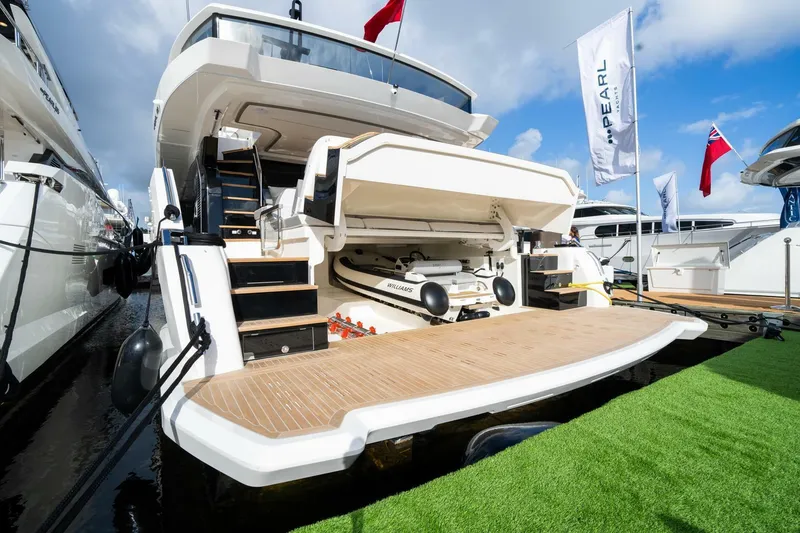 Slide: The Image of Luxury Pearl 82 yacht, 2026 model, with open garage and tender, docked at marina. - 45