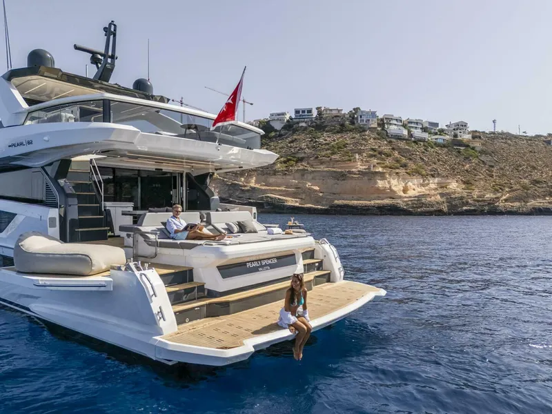 Slide: The Image of Luxury Pearl 82 yacht cruising near rocky coastline, 2026 model, with people relaxing on deck. - 5