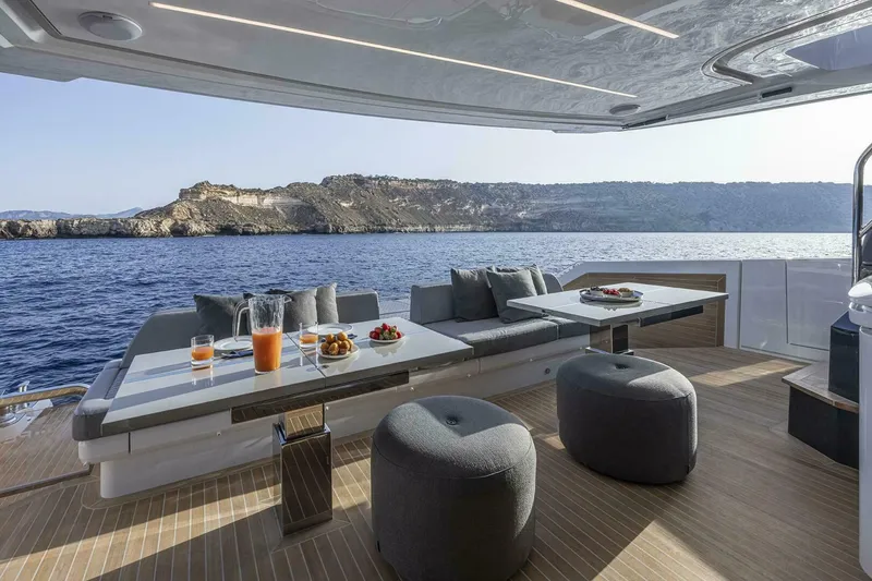 Slide: The Image of Luxurious Pearl 82 yacht deck with ocean view, featuring elegant seating and refreshments, 2026 model. - 6