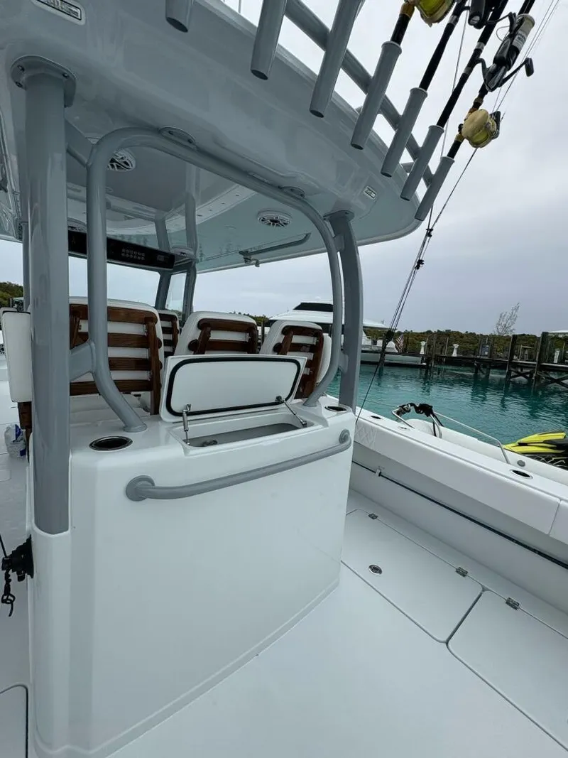 Slide: The Image of 2026 Freeman 38 boat interior with seating and fishing rods, docked by clear blue water. - 20