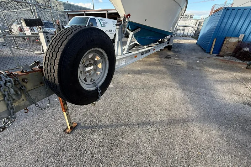 Slide: The Image of Trailer with 1998 Contender 35 Express boat in industrial yard setting. - 100