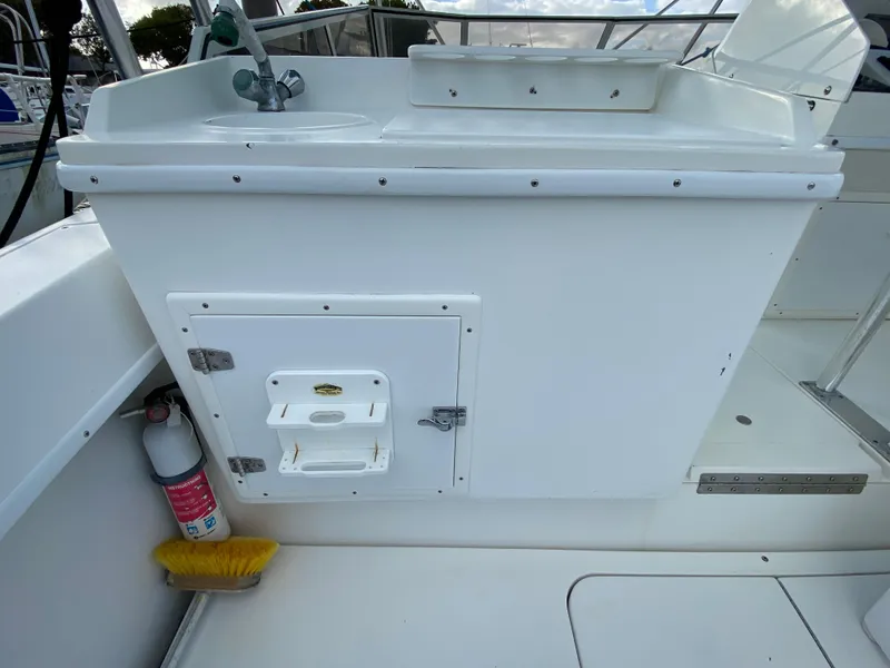 Slide: The Image of 1998 Contender 35 Express boat deck with storage compartments and cooler. - 12