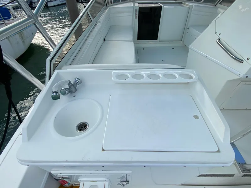 Slide: The Image of 1998 Contender 35 Express boat deck with storage compartment and cooler. - 14