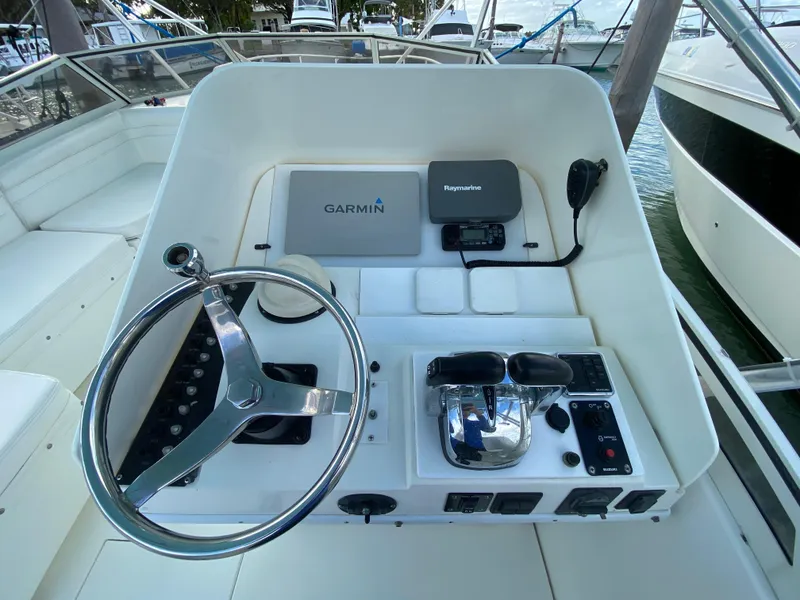 Slide: The Image of 1998 Contender 35 Express boat cockpit with steering wheel and controls. - 19