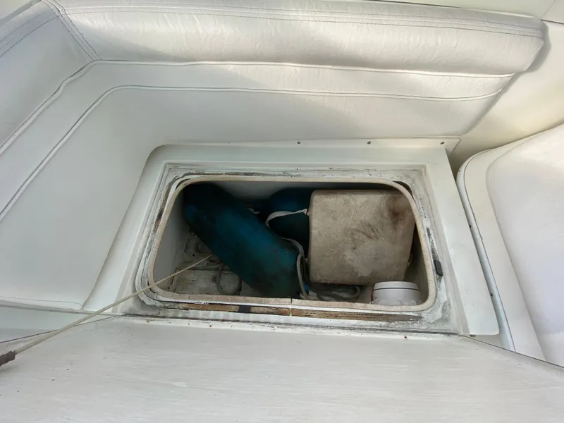 Slide: The Image of 1998 Contender 35 Express boat interior with open storage compartment and seating area. - 33