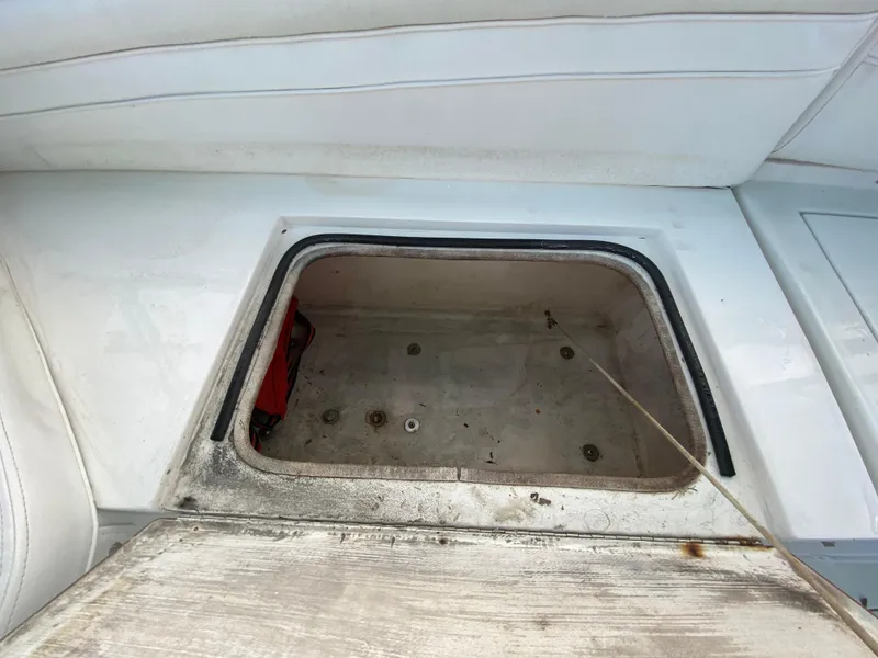 Slide: The Image of 1998 Contender 35 Express boat interior with white seating and storage compartments. - 36