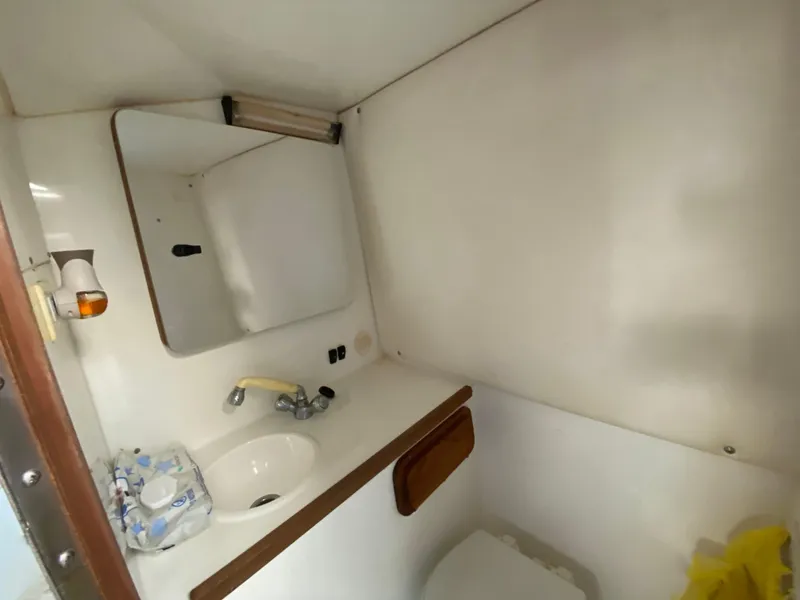 Slide: The Image of 1998 Contender 35 Express boat interior with white seating and storage compartments. - 45