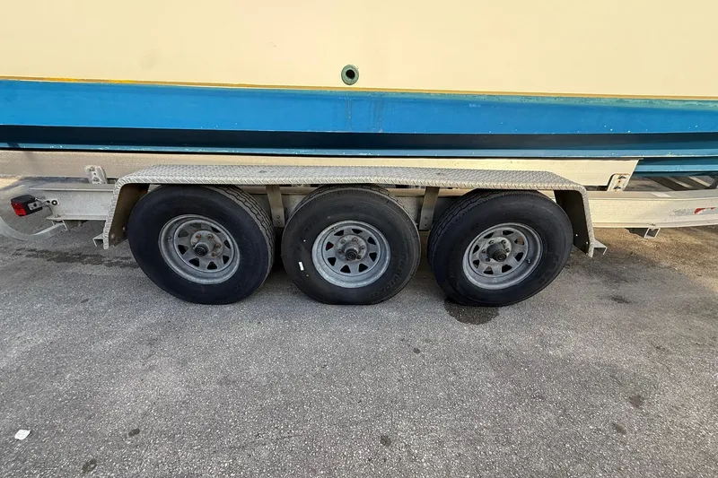 Slide: The Image of Triple-axle trailer with Contender 35 Express boat, 1998 model, on pavement. - 99