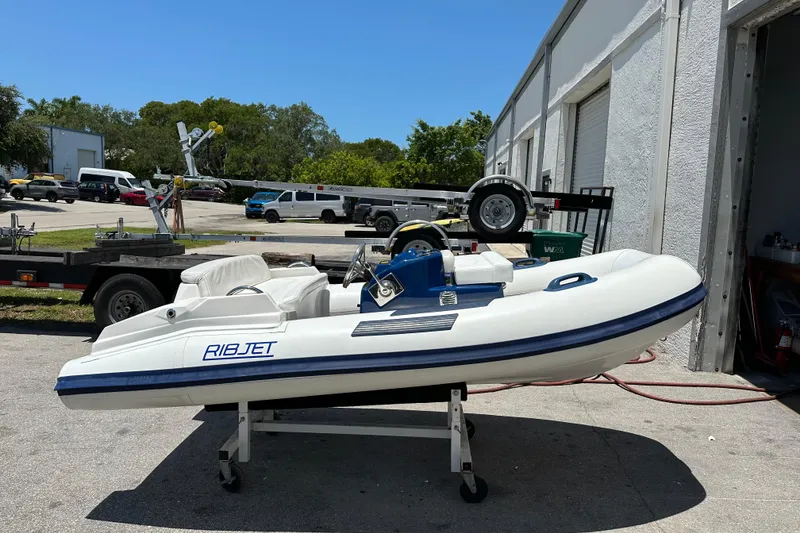 The Image of 2020 Ribjet 10 inflatable boat on a stand outside a garage. - 0