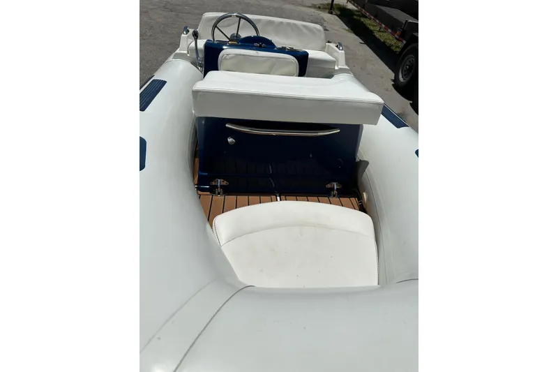 Slide: The Image of 2020 Ribjet 10 boat interior with white seating and wooden flooring. - 5