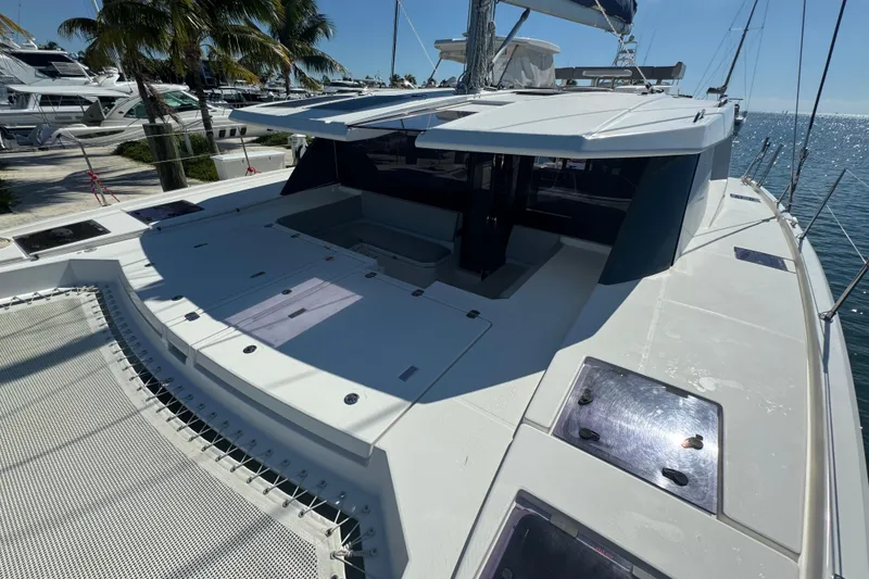 Slide: The Image of 2021 Leopard 45 catamaran deck with sleek design, docked near palm trees and ocean. - 104