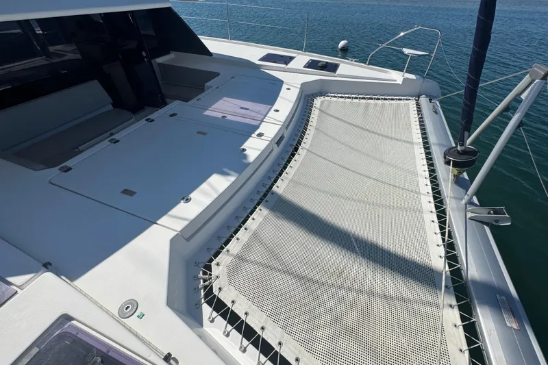 Slide: The Image of Deck view of 2021 Leopard 45 catamaran with netting over blue water. - 108