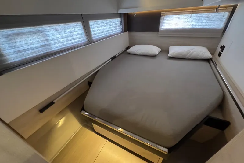 Slide: The Image of Interior of a 2021 Leopard 45 yacht cabin with a cozy bed and windows. - 135
