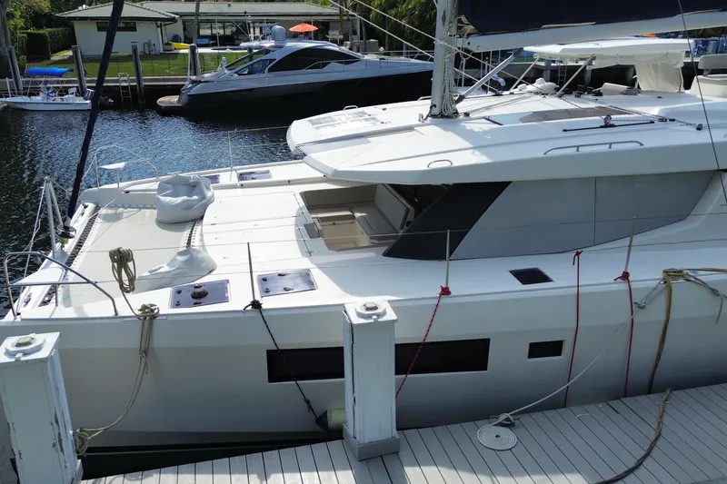 Slide: The Image of 2021 Leopard 45 catamaran docked at marina, showcasing sleek design and spacious deck. - 17