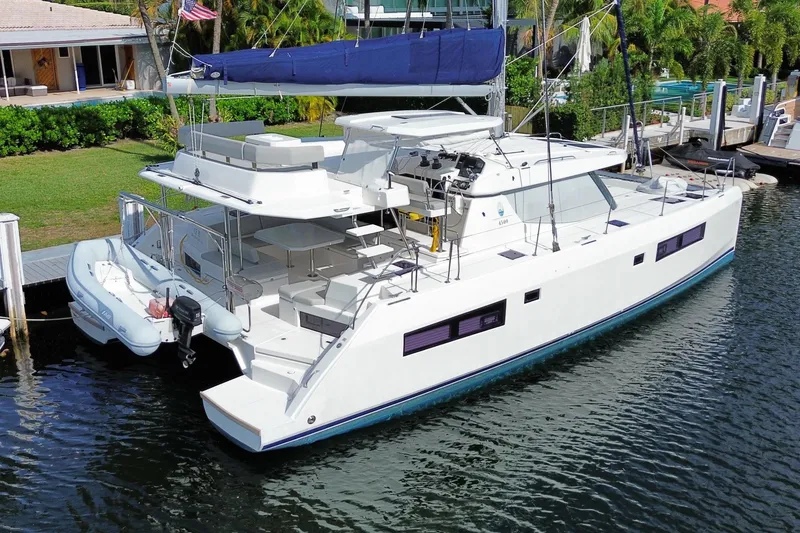 Slide: The Image of 2021 Leopard 45 catamaran docked in a scenic marina setting. - 2