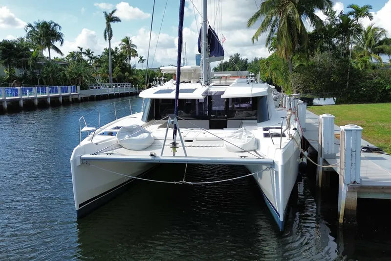 Slide: The Image of 2021 Leopard 45 catamaran docked by palm trees, under a clear blue sky. - 21