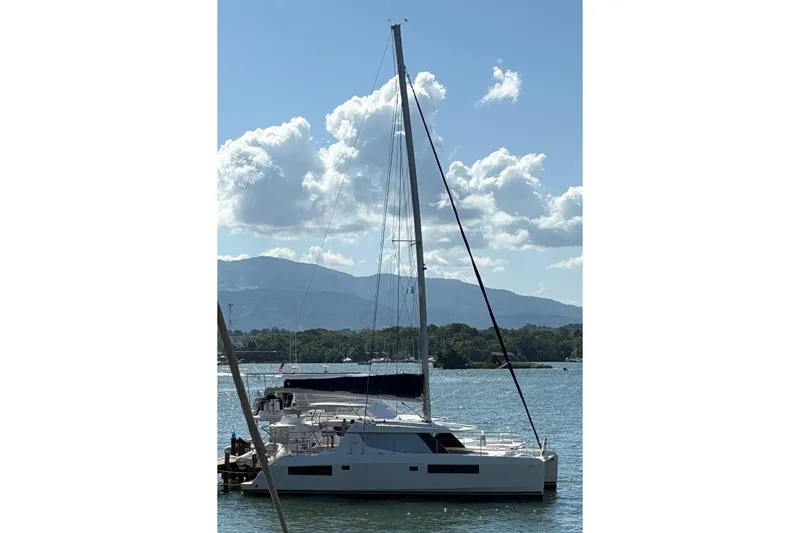 Slide: The Image of 2021 Leopard 45 catamaran docked on a sunny day with mountains in the background. - 22