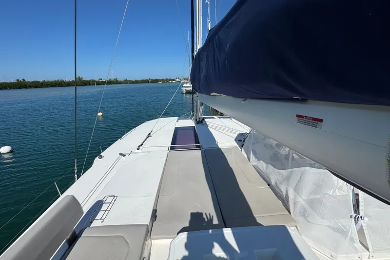 Slide: The Image of 2021 Leopard 45 catamaran deck with blue sail cover on calm water. - 33