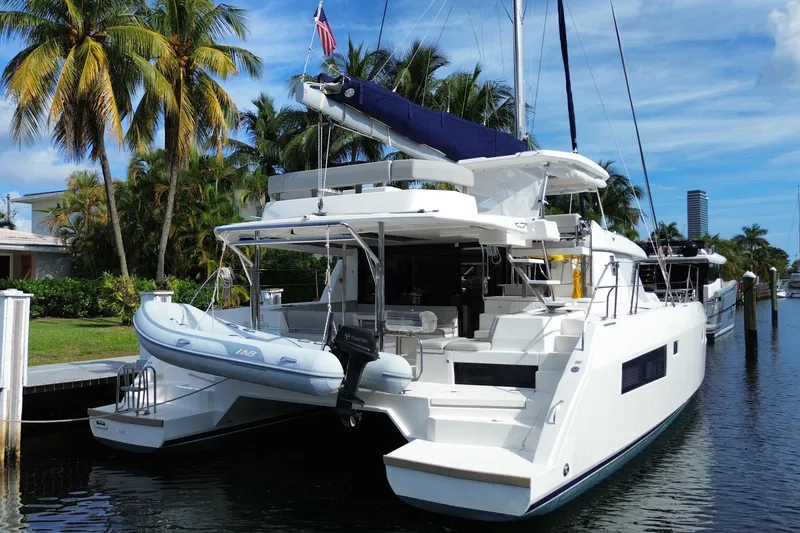 Slide: The Image of Luxury 2021 Leopard 45 catamaran docked by palm trees, featuring sleek design and spacious deck. - 5