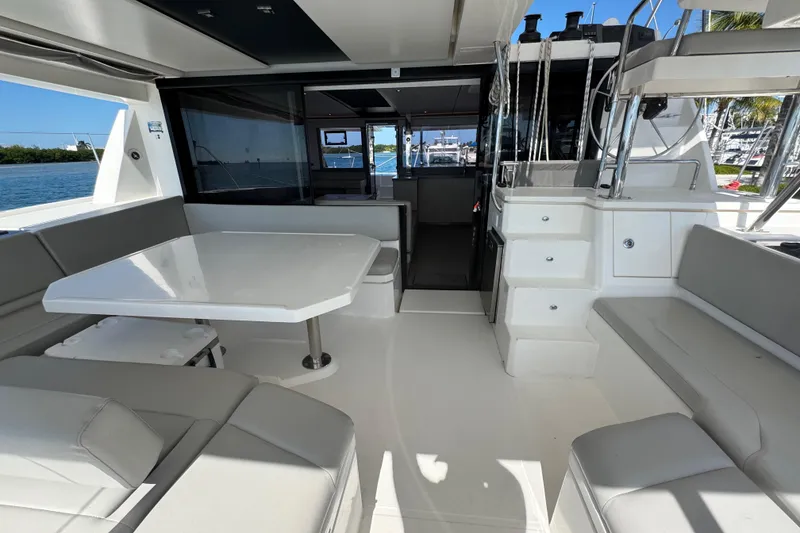 Slide: The Image of Spacious interior of 2021 Leopard 45 catamaran with seating and table, docked by the water. - 67