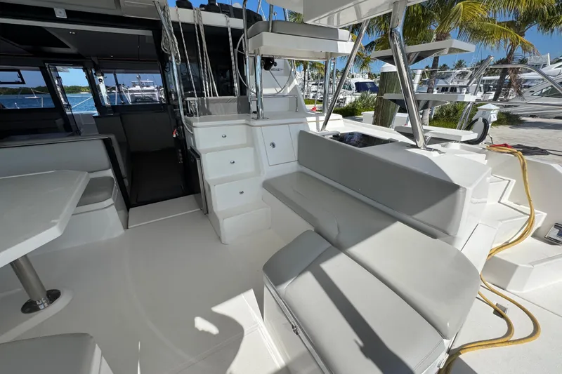 Slide: The Image of Spacious deck of 2021 Leopard 45 catamaran with seating and table, docked near palm trees. - 69