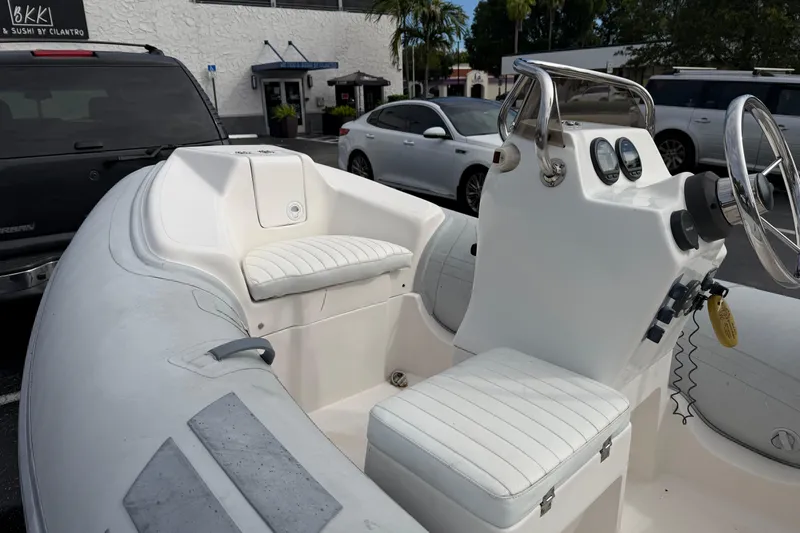 Slide: The Image of Inflatable boat Caribe 12, 2011 model, parked near vehicles in a lot. - 3