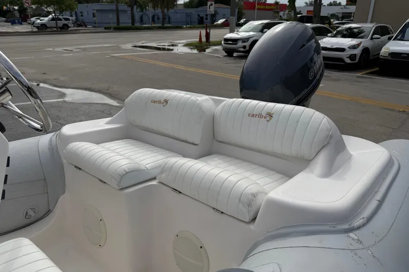 Slide: The Image of Interior of a 2011 Caribe 12 boat with white cushioned seating. - 4
