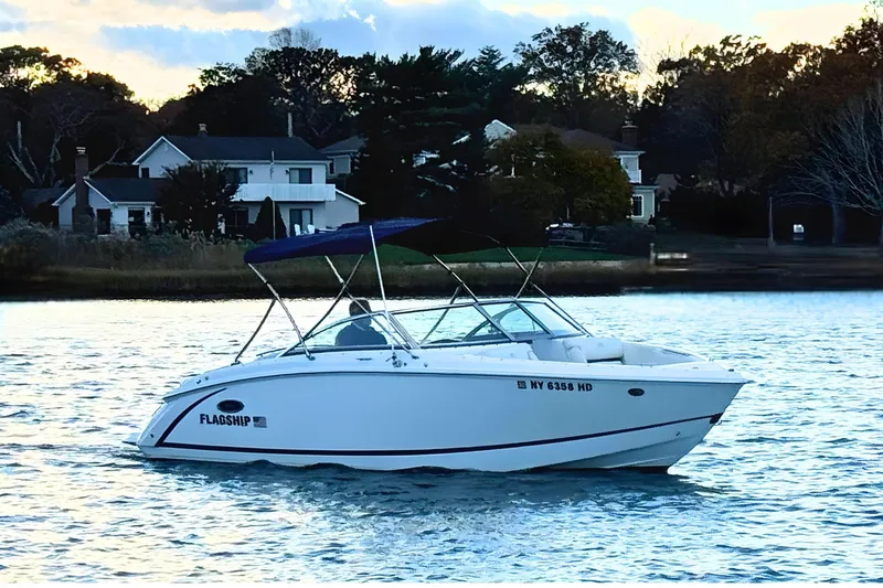 Slide: The Image of 2019 Cobalt R3 boat cruising on a serene lake near waterfront homes. - 1