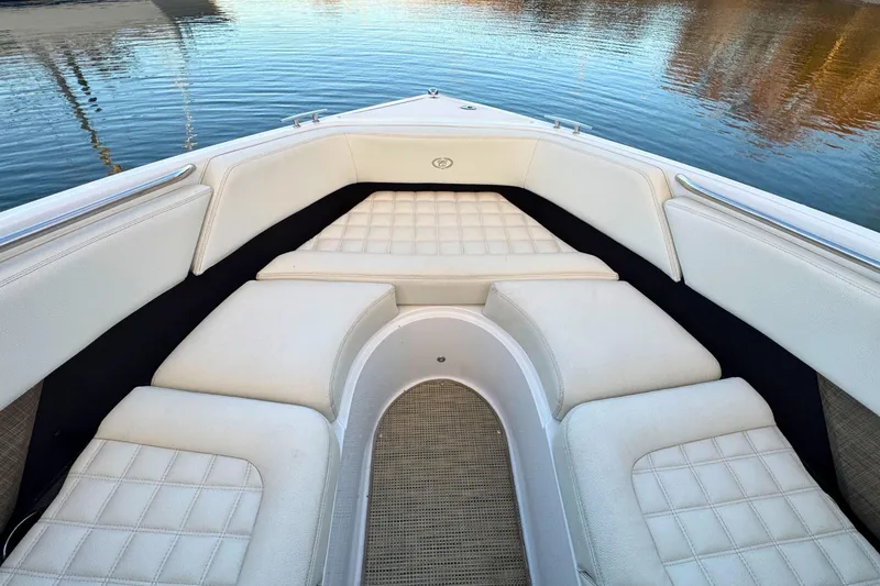 Slide: The Image of 2019 Cobalt R3 boat interior with white cushioned seating on calm water. - 33