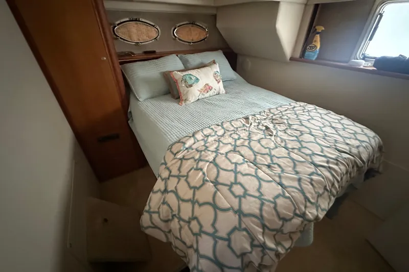 Slide: The Image of 1998 Silverton 372 Motor Yacht helm with gauges and controls, overlooking serene waterway. - 10