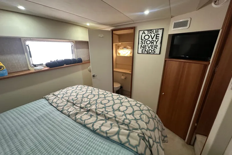 Slide: The Image of Cozy bedroom in a 1998 Silverton 372 Motor Yacht with nautical decor. - 13