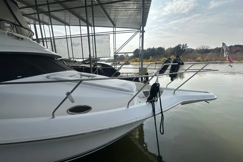 Slide: The Image of 1998 Silverton 372 Motor Yacht docked under a covered marina on a sunny day. - 2