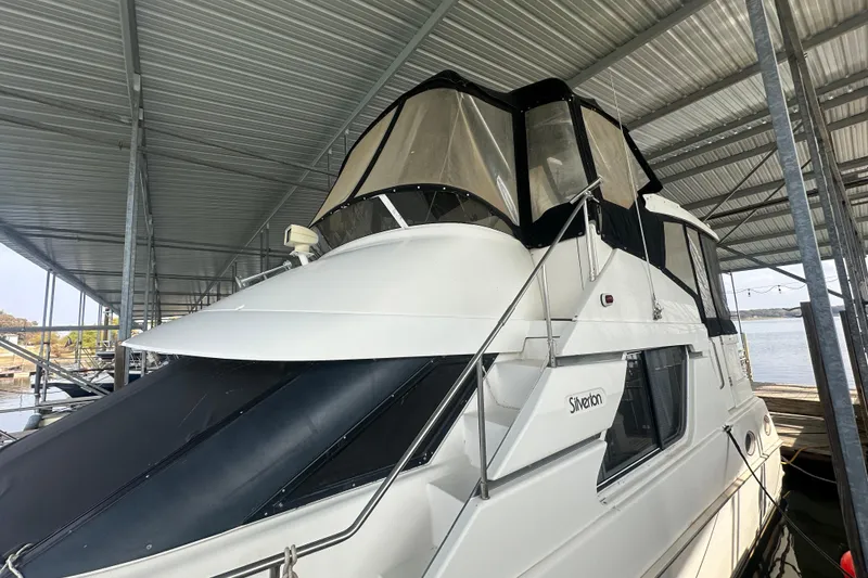 Slide: The Image of 1998 Silverton 372 Motor Yacht helm with steering wheel, gauges, and navigation equipment. - 8