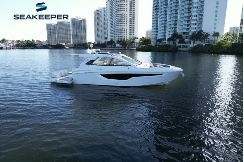 The Image of 2021 Cruisers Yachts 42 GLS OB on water, city skyline in background. - 0