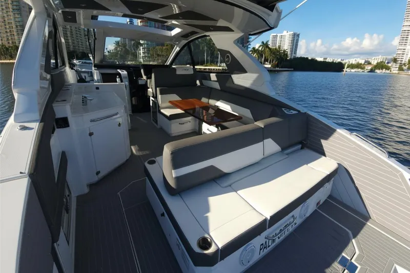 Slide: The Image of 2021 Cruisers Yachts 42 GLS OB interior with seating and table, docked by waterfront. - 11
