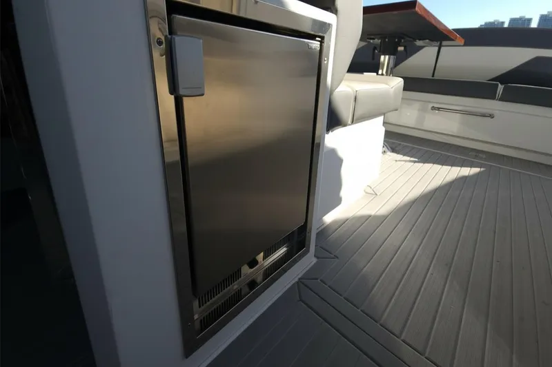 Slide: The Image of 2021 Cruisers Yachts 42 GLS OB deck with stainless steel fridge and seating area. - 16
