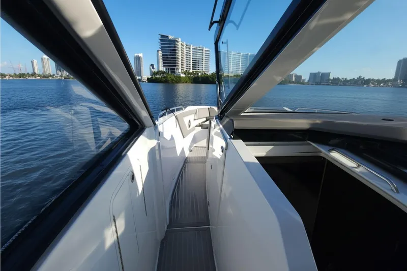 Slide: The Image of 2021 Cruisers Yachts 42 GLS OB, sleek deck view, city skyline in background. - 21