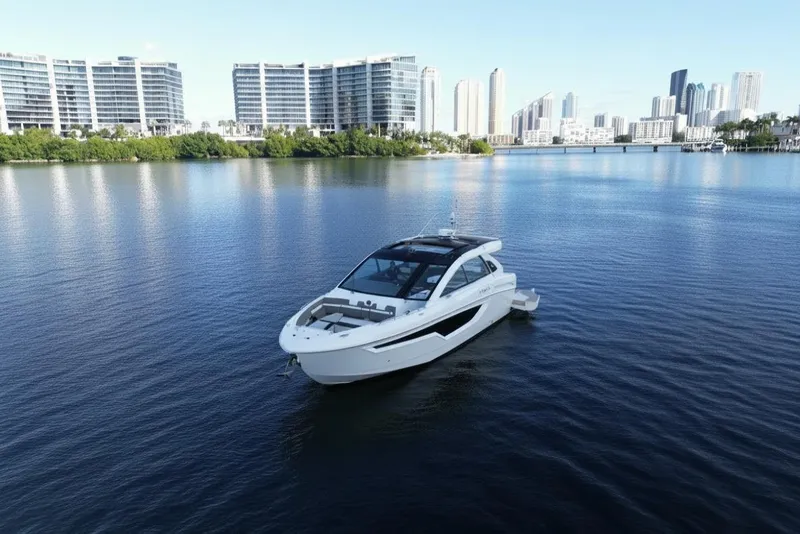 Slide: The Image of 2021 Cruisers Yachts 42 GLS OB on calm water with city skyline backdrop. - 3