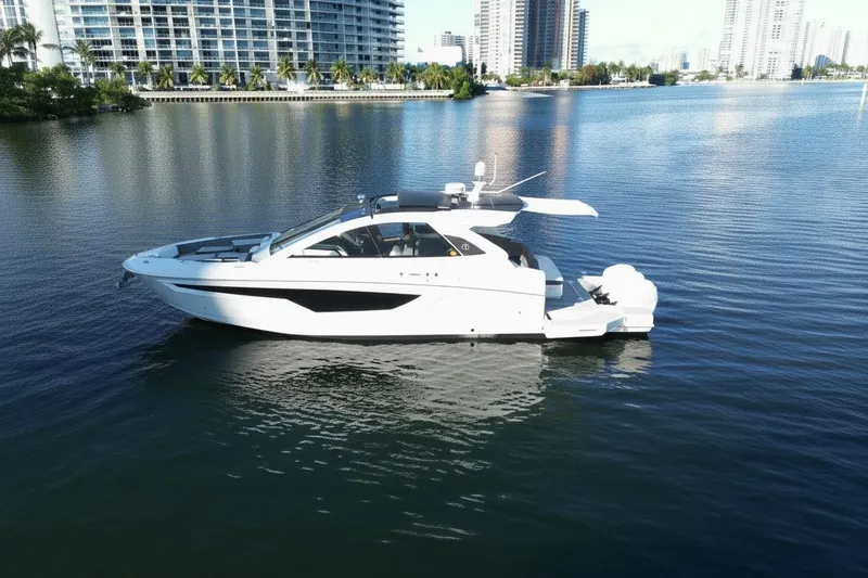 Slide: The Image of 2021 Cruisers Yachts 42 GLS OB on calm water, cityscape background. - 4