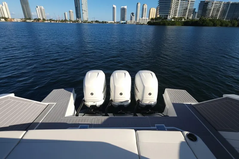 Slide: The Image of 2021 Cruisers Yachts 42 GLS OB with triple outboard engines on a calm waterfront. - 9