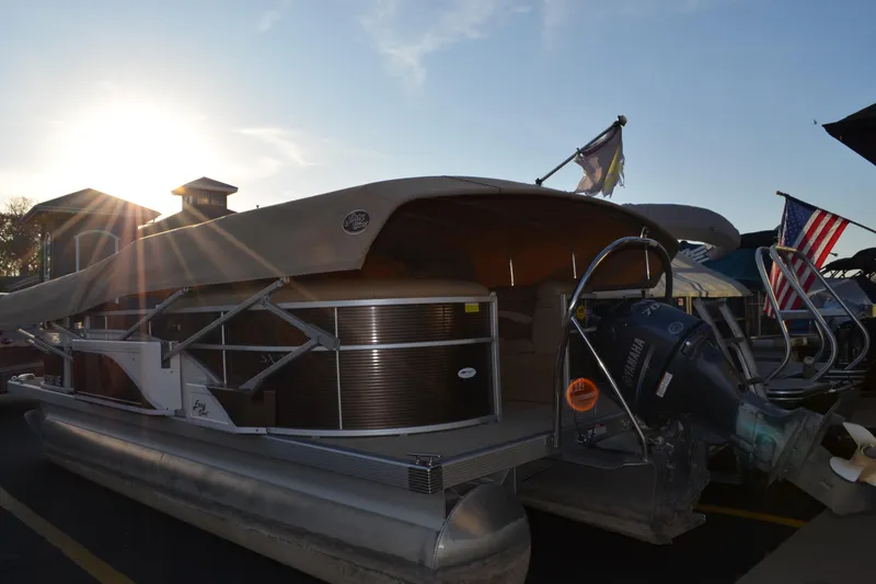 Slide: The Image of 2018 Bennington 21 SSRX pontoon boat with canopy, docked at sunset. - 1