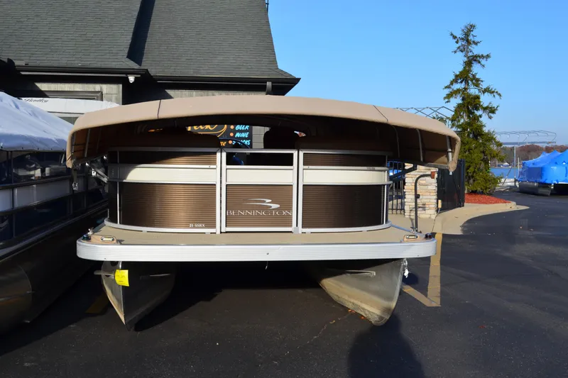 Slide: The Image of 2018 Bennington 21 SSRX pontoon boat parked outdoors on a sunny day. - 2