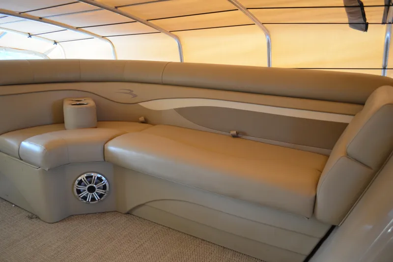 Slide: The Image of 2018 Bennington 21 SSRX boat interior with beige seating and cup holders. - 8
