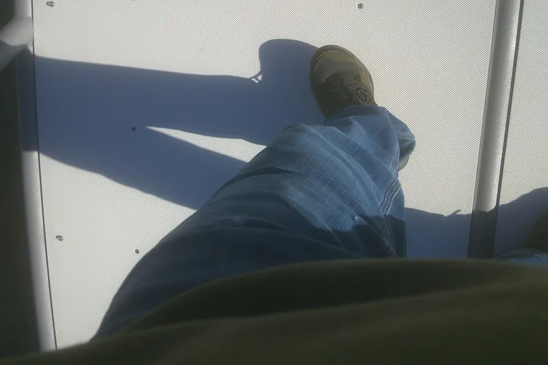 Slide: The Image of Person standing on a 2024 Godfrey Monaco 255 SD boat deck, wearing jeans and shoes. - 12