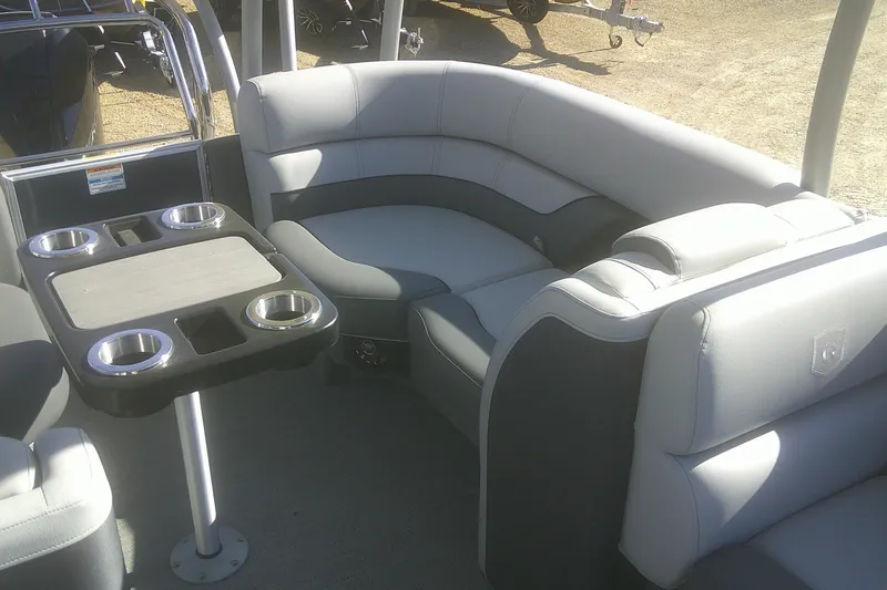 Slide: The Image of 2024 Godfrey Monaco 255 SD boat interior with gray seating and cupholder table. - 3