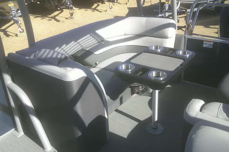 Slide: The Image of 2024 Godfrey Monaco 255 SD boat interior with gray seating and cupholder table. - 4