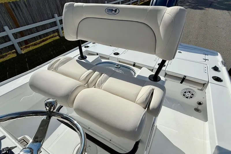 Slide: The Image of 2026 Sea Hunt BX 22 BR boat interior with white cushioned seating and steering wheel. - 10